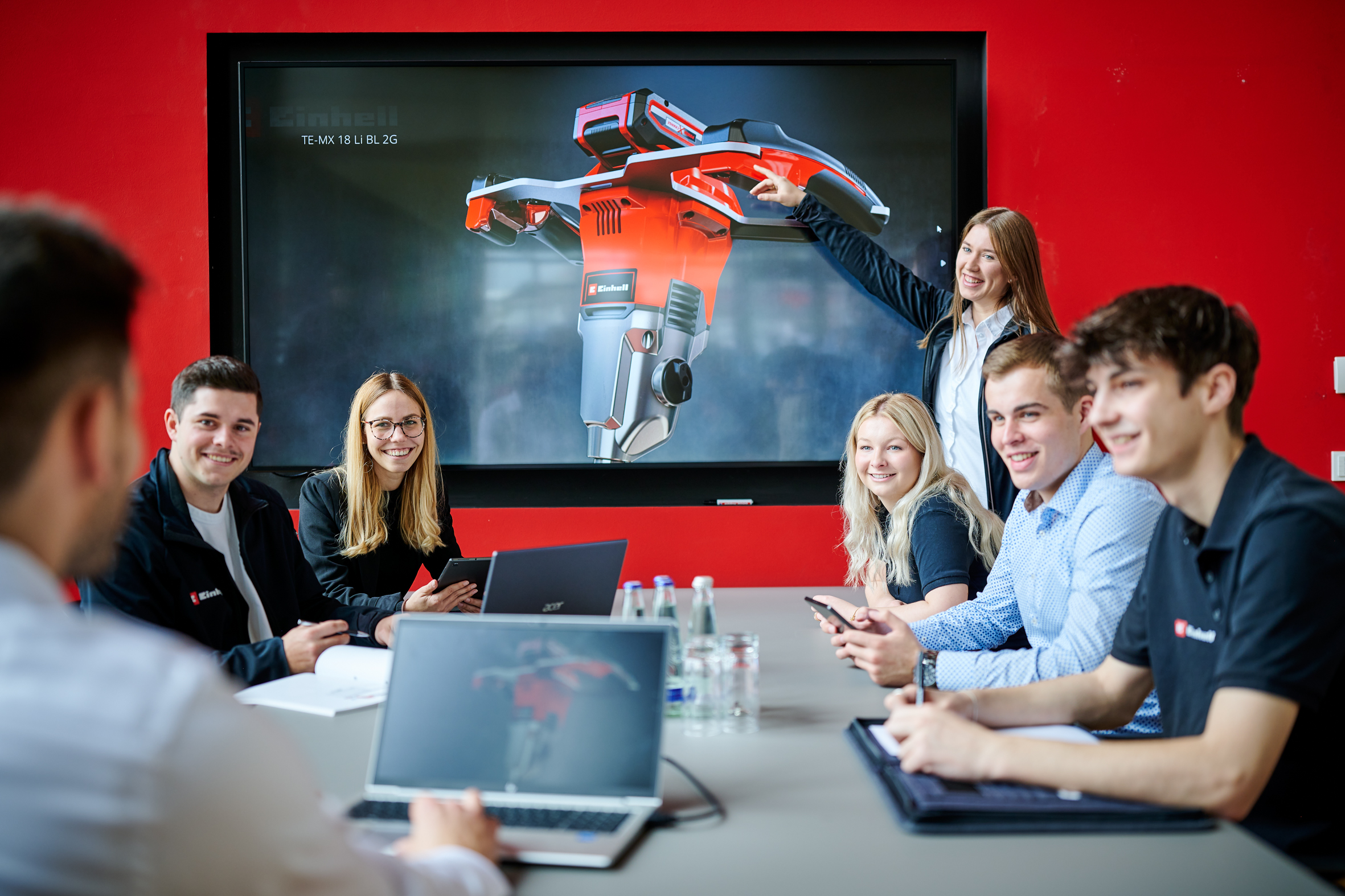 A group of people sitting in a meeting room and talking with each other.
