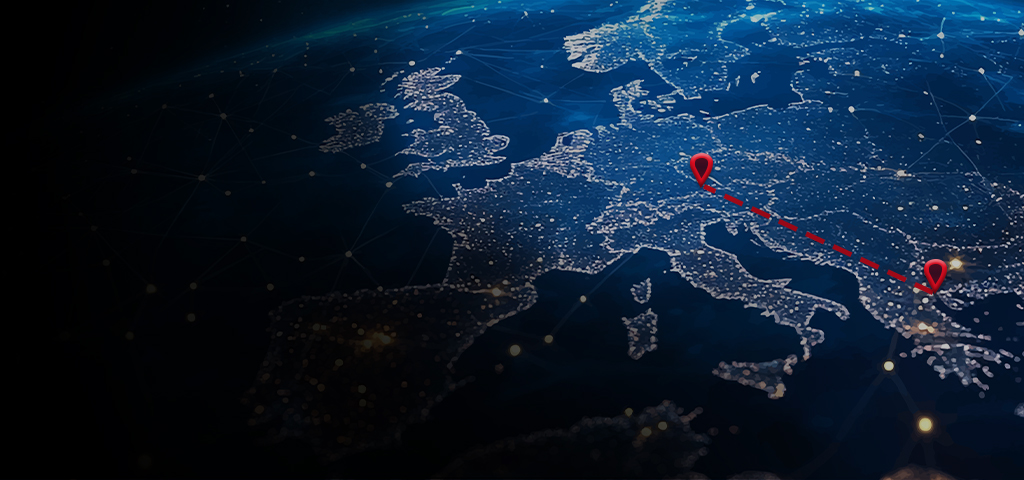 Satellite image of Europe at night with two red markers and a dashed line connecting Landau an der Isar and Thessaloniki.