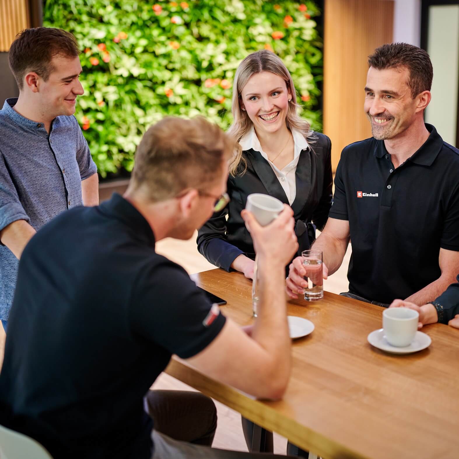 A group of people standing in a circle and talking to each other.